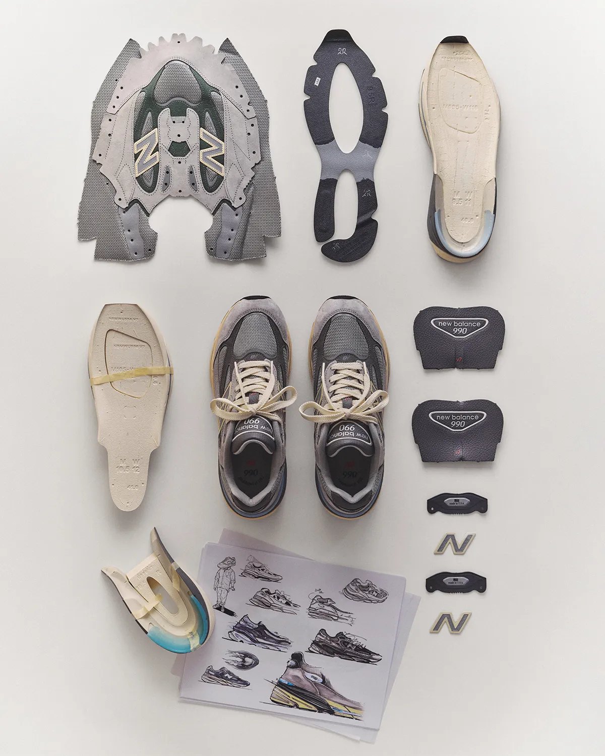 ชิ้นส่วนของ New Balance 990v7 วางเรียงพร้อมสเก็ตช์